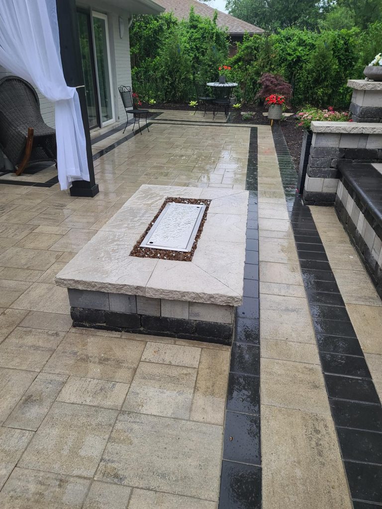 Linear gas fire table set into a paver patio with contrasting border banding